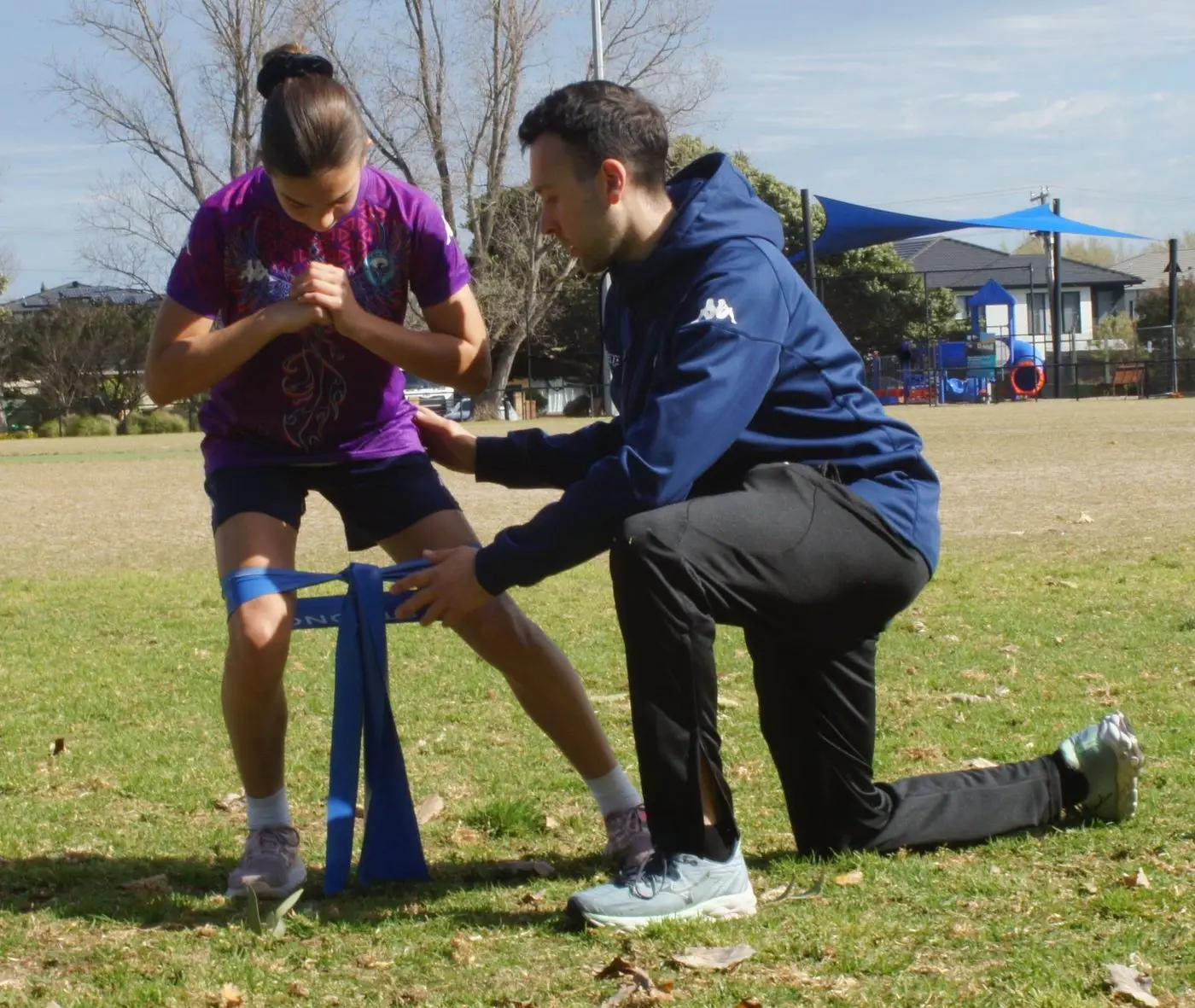 Jake coaching a young footballer through a banded squat
